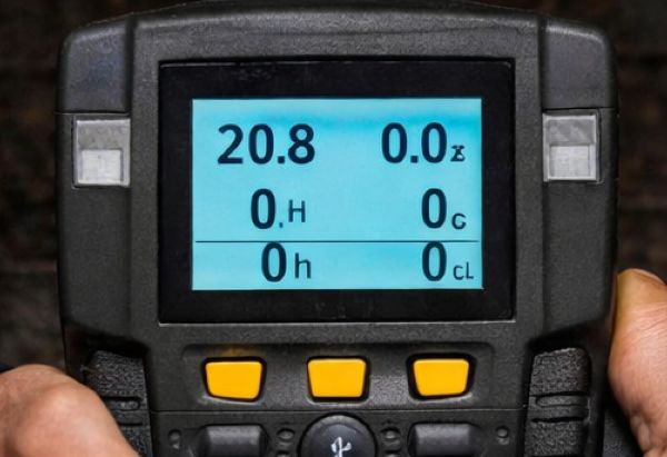 Close-up of gas detector screen displaying oxygen, toxic gas, and LEL readings for confined space safety.
