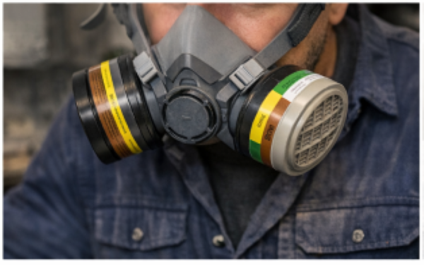 Respirator with color-coded chemical cartridges indicating protection against organic vapors, acid gases, and ammonia