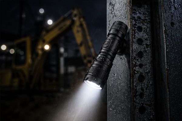 Weather-resistant rechargeable flashlight with magnetic base attached to metal surface in wet construction environment.